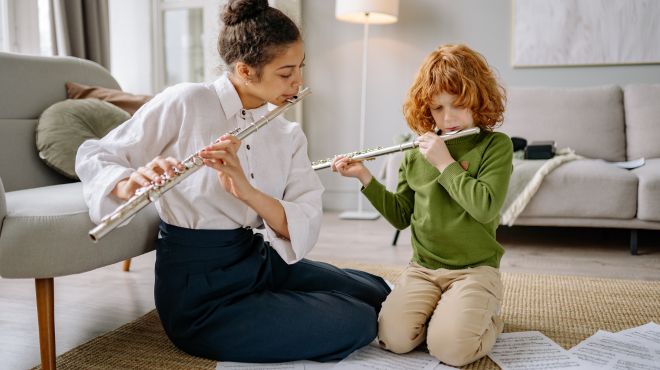 someone teaching a little boy to play a music instrument