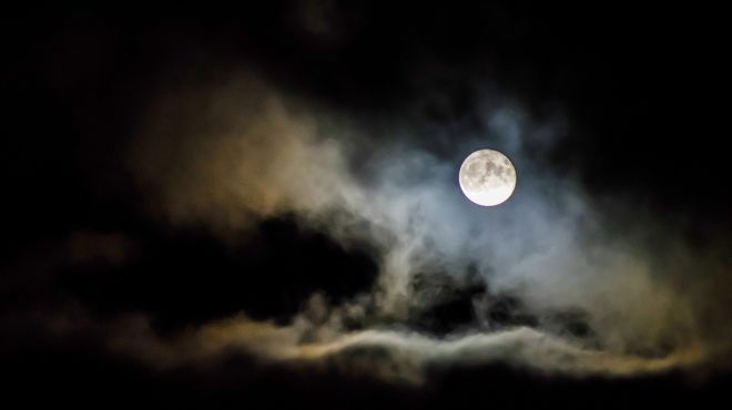 person is dreaming of a full moon at night along with heavy clouds