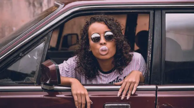 girl chewing a gum in a car