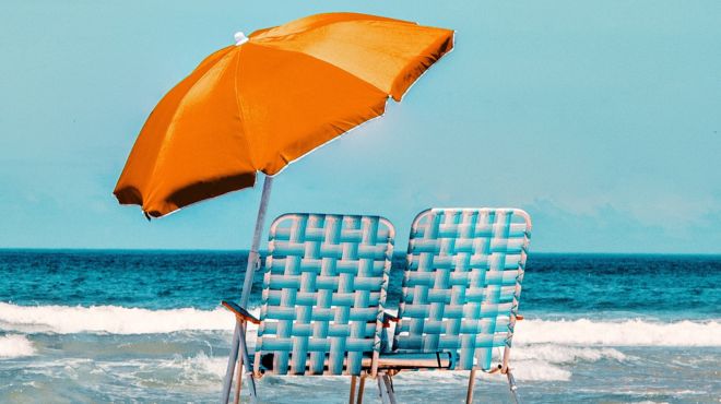 two chairs and umbrella in a blue ocean beach