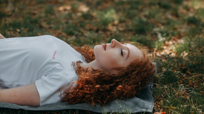 girl dreaming about herself sleeping on the ground in the park
